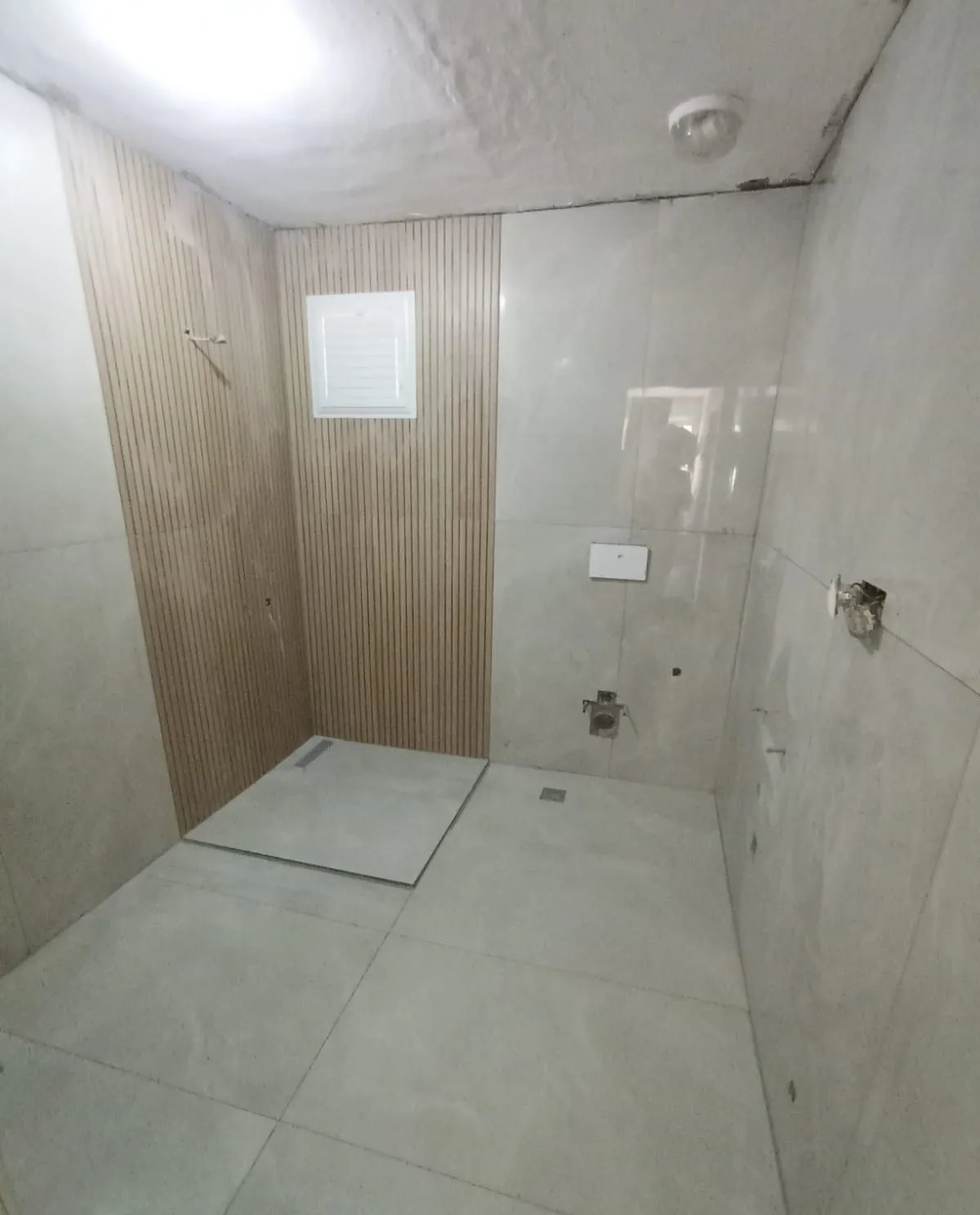 Ahşap desenli dikey vurgu şeridi ve duş kanallı banyo zemini